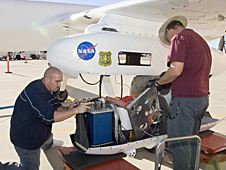 Dryden Ikhana ground crewmen Gus Carreno, left, and James Smith load the thermal-infrared imaging scanner pallet into the Ikhana's underwing payload pod.