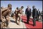 Walking with President Festus Gontebanye Mogae of Botswana, President George W. Bush and Laura Bush (not pictured) are greeted by traditional dancers upon their arrival at Sir Seretse Khama International Airport Thursday, July 10, 2003.