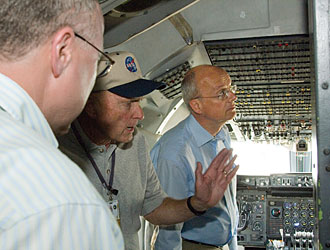 SOFIA chief pilot Gordon Fullerton, center, gives a group of VIP visitors from Germany a tour of the NASA 747SP cockpit.