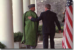 President George W. Bush and Chairman Karzai walk along the colonnade in the Rose Garden after their joint press conference Jan. 28. "The United States is committed to building a lasting partnership with Afghanistan," said the President. "We'll help the new Afghan government provide the security that is the foundation for peace." White House photo by Tina Hager.