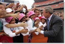 President George W. Bush is greeted by the Afghan girls soccer team after delivering remarks to the athletes at the International Children's Games and Cultural Festival in Cleveland, Ohio, July 30, 2004.  White House photo by Paul Morse