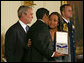President George W. Bush presents the Presidential Medal of Freedom to Yan Valdes Morejon and Winnie Biscet in honor of their father Oscar Elias Biscet during a ceremony Monday, Nov. 5, 2007, in the East Room. "Oscar Biscet is a healer -- known to 11 million Cubans as a physician, a community organizer, and an advocate for human rights," said the President about the imprisoned physician. "The international community agrees that Dr. Biscet's imprisonment is unjust, yet the regime has refused every call for his release." White House photo by Joyce N. Boghosian