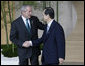 Prime Minister Yasuo Fukuda of Japan greets President George W. Bush as he arrives Monday, July 7, 2008, for the official G8 family photo in the grand lobby of the Windsor Hotel Toya Resort and Spa in Toyako, Japan. White House photo by Eric Draper