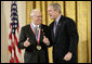 President George W. Bush presents a National Medal of Science, Monday, Feb. 13, 2006 to Dr.Norman E. Borlaug of Texas A&M University, during ceremonies in the East Room of the White House. Borlaug was honored for his work in creating disease resistant and high-yield wheat, providing a new quality food source for millions of people around the world. White House photo by Eric Draper