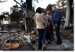 President George W. Bush meets with the Bentley family during a walking tour of the fire-damaged Harbison Canyon community in San Diego, Calif., Tuesday, Nov. 4, 2003. The Bentley family lost their home in last week's wildfires.  White House photo by Eric Draper