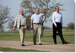 Hosting a lunch and tour at his ranch, President George W. Bush waves to the press while walking with Canadian Prime Minister Paul Martin, left, and Mexican President Vicente Fox in Crawford, Texas, March 23, 2005.  White House photo by Eric Draper