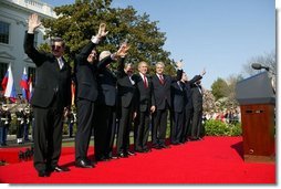 President George W. Bush waves with Prime Ministers of seven countries after a South Lawn ceremony welcoming them into NATO Monday, March 29, 2004. From left are: Prime Minister Indulis Emsis of Latvia, Prime Minister Anton Rop of Slovenia, Prime Minister Algirdas Brazauskas of Lithuania, Prime Minister Mikulas Dzurinda of the Slovak Republic, President George W. Bush, Prime Minister Adrian Nastase of Romania, Prime Minister Simeon Saxe-Coburg Gotha of Bulgaria, Prime Minister Juhan Parts of Estonia, and NATO Secretary General Jaap de Hoop Scheffer.  White House photo by Susan Sterner