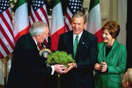 President George W. Bush and Laura Bush receive a bowl of Shamrock from Ireland's Prime Minister Bertie Ahren during the annual ceremony celebrating St. Patrick's Day in the Roosevelt Room Wednesday, March 17, 2004. White House photo by Tina Hager.