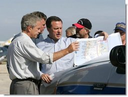 President George W. Bush receives a briefing on hurricane damage from FEMA Director Mike Brown in Punta Gorda, Florida, Sunday, Aug. 15, 2004.  White House photo by Eric Draper