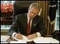 President George W. Bush signs executive orders and directives Friday, August 27, 2004, in the Oval Office, that strengthen the intelligence capabilities of the United States and take action consistent with certain recommendations of the 9/11 Commission. White House photo by Paul Morse