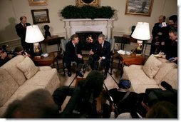 President George W. Bush and President Aleksander Kwasniewski talk with the press in the Oval Office Tuesday, Jan. 27, 2004. After their meeting, President Bush hosted a lunch for President Kwasniewski.   White House photo by Eric Draper