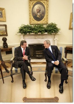 President George W. Bush and German Chancellor Gerhard Schroeder talk just before meeting with the press in the Oval Office Monday, June 27, 2005.  White House photo by Eric Draper