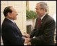 President George W. Bush welcomes Italian Prime Minister Silvio Berlusconi to the Oval Office at the White House, Monday, Oct. 31, 2005 in Washington. White House photo by Eric Draper