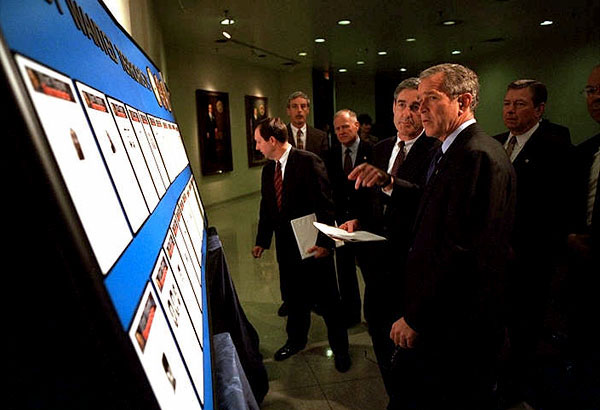 White House photo by Eric Draper. President George W. Bush looks over the newly created list of Most Wanted Terrorists with FBI Director Rober Mueller at the agency's headquarters Oct. 10.