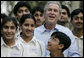 President George W. Bush poses with Pakistani youth from the Schola Nova school and the Islamabad College for Boys, Saturday, March 4, 2006, at the Raphel Memorial Gardens on the grounds of the U.S. Embassy in Islamabad, Pakistan, following his participation in a cricket clinic. White House photo by Eric Draper