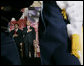 President George W. Bush and U.S. Attorney General Alberto Gonzales are framed by a military honor guard Monday, March 27, 2006, during the Naturalization Ceremony at the Daughters of the American Revolution Administration Building in Washington. President Bush, speaking to those who were swearing-in as new U.S. citizens, said that each generation of immigrants brings a renewal to our national character and adds vitality to our culture. White House photo by Eric Draper