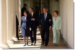 President George W. Bush and Prime Minister Tony Blair walk along the colonnade with their wives Mrs. Laura Bush and Mrs. Cherie Blair after a press conference in the Rose Garden of the White House on April 16, 2004.  White House photo by Paul Morse