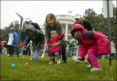 Slipping and sliding, eggs are tossed in rainy race on the South Lawn during the 2004 White House Easter Egg Roll Monday, April 12, 2004. Because of inclement weather, the annual event closed at noon. None