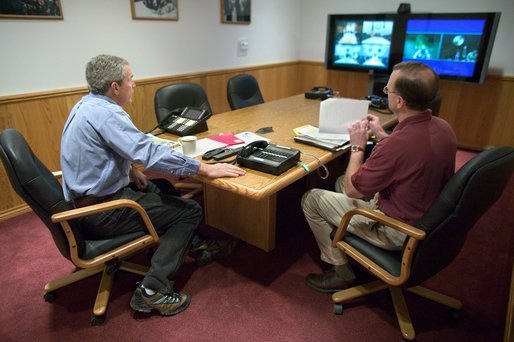 President George W. Bush conducts a National Security Council meeting via teleconference with General John Abizaid, in Crawford, Texas, Wednesday, April 7, 2004. The President received an update on military operations in Iraq. Also present is NSC Executive Secretary Greg Schulte. White House photo by Eric Draper.