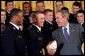 President George W. Bush laughs with Midshipmen Eddie Carthan, left, and team captain Craig Candeto during the presentation of the Commander-In-Chief Trophy to the U.S. Naval Academy football team in the East Room Monday, April 19, 2004. The trophy is awarded to the Service Academy with the year's best overall record in NCAA football games versus the other academies. White House photo by Tina Hager.
