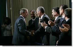 President George W. Bush greets audience members at the Hispanic Alliance for Free Trade, Thursday, July 21, 2005, at the Organization of American States in Washington. President Bush thanked the group for their support of CAFTA.  White House photo by Eric Draper