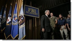 President George W. Bush walks on stage Monday, July 11, 2005, at the FBI Academy in Quantico, Va., where he spoke on the ongoing accomplishments and efforts in the war on terror.  White House photo by Eric Draper