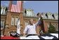 President George W. Bush waves to the estimated 3,000 people in attendance at an Independence Day celebration Monday, July 4, 2005, at West Virginia University in Morgantown. Said the President, "The history we celebrate today is a testament to the power of freedom to lift up a whole nation." White House photo by Krisanne Johnson