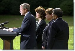 President George W. Bush discusses his decision to seek an injunction under the Taft-Hartley Act to stops the lockouts of America's western ports during a press conference on the South Lawn of the White House Tuesday, Oct. 8. Accompanying the President is Secretaries Elaine Chao, left, Ann Veneman, center, and Norm Mineta. "Americans are working hard every day to bring our economy back from recession," said the President. "This nation simply cannot afford to have hundreds of billions of dollars a year in potential manufacturing and agricultural trade sitting idle.".
