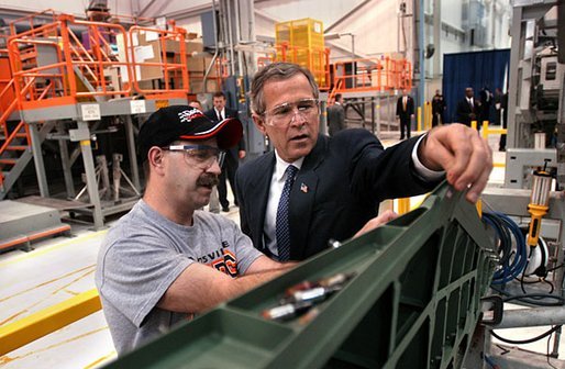 President George W. Bush inspects an F-18 part with Boeing Employee Rocky Mayberry during a tour of the Boeing F-18 Production Facility in St. Louis, Mo., Wednesday, April 16, 2003. White House photo by Eric Draper
