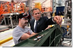 President George W. Bush inspects an F-18 part with Boeing Employee Rocky Mayberry during a tour of the Boeing F-18 Production Facility in St. Louis, Mo., Wednesday, April 16, 2003.  White House photo by Eric Draper