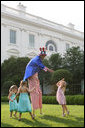 Uncle Sam on stilts reaches out to slap high-five with children at the annual Congressional Picnic on the South Lawn of the White House, Thursday evening, June 5, 2008. White House photo by Grant Miller