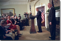 President George W. Bush and Jim Towey pause to smile at Mr. Towey's children during the Ceremony in which the President names him as the Director of the Faith-Based & Community Initiatives Director in the Roosevelt Room Feb. 1. "The purpose of this initiative recognizes the power of faith in helping heal some of our nation's wounds," said the President. "And today, I'm honored to name Jim Towey as its new head and new director. He has served a Republican senator and a Democratic governor. He understands there are things more important than political parties." White House photo by Eric Draper.