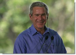 President George W. Bush smiles as he listens through an earpiece to a translation of the remarks by Brazil President Luiz Inacio Lula da Silva Saturday, Nov. 6, 2005, in Brasilia, Brazil. White House photo by Paul Morse