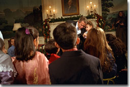 President George W. Bush takes a small break hear to what Alexandria Hudome, 3, has to say as he reads a poem to Muslim children during Eid Al-Fitr at the White House December 17, 2001. "Eid is a time of joy, after a season of fasting and prayer and reflection," said President Bush. "Each year, the end of Ramadan means celebration and thanksgiving for millions of Americans." White House photo by Tina Hager.