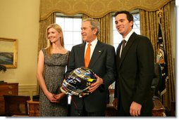 President George W. Bush holds a racing helmet as he poses with 2007 NASCAR Nextel Cup Champion Jimmie Johnson and wife, Chandra Johnson Tuesday Feb. 5, 2008, in the Oval Office. White House photo by Chris Greenberg