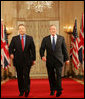 President George W. Bush and Prime Minister Tony Blair of Great Britain, walk through Cross Hall en route to the East Room Thursday night, May 25, 2006, for a joint press availability during which the President said of Iraq's new government, "The United States and Great Britain will work together to help this new democracy succeed." White House photo by Shealah Craighead