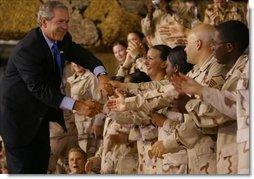 President George W. Bush greets troops during his introduction at Camp As Sayliyah in Doha, Qatar, Thursday, June 5, 2003.   White House photo by Paul Morse