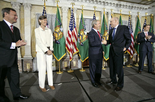 President George W. Bush congratulates Henry Paulson at his swearing in as the Secretary of Treasury at the Department of the Treasury Monday, July 10, 2006. "He has an intimate knowledge of global markets. He will work to keep this economy of ours competitive and growing, and he will work to ensure fair treatment for America's goods and services across the world," said President Bush in his remarks. White House photo by Eric Draper