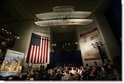 President George W. Bush speaks beneath a replica of the Wright Brother’s plane as he addresses a news conference at the Museum of Science and Industry in Chicago, Friday, July 7, 2006, speaking on the economy, immigration reform and security issues. White House photo by Eric Draper