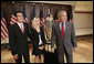 President George W. Bush meets with Sam Hornish Jr., the 2006 winner of the Indianapolis 500, and his wife, Crystal Hornish, as they stand next to the 500 race Borg-Warner Trophy Tuesday, July 18, 2006, at the Eisenhower Executive Office Building in Washington. White House photo by Eric Draper