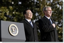 President George W. Bush and Premier Wen Jiabao of China stand for the playing their national anthems during an Arrival Ceremony on the South Lawn Tuesday, Dec. 9, 2003.   White House photo by Paul Morse