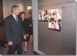 President George W. Bush and First Lady Laura Bush look at an exhibit showing the famous photo of a firefighter carrying a baby girl at the Oklahoma City Murrah Federal Building bombing at the Oklahoma City National Memorial February 19, 2001. The President attended the dedication ceremony of the memorial. (White House Photo by Paul Morse)