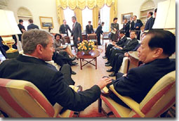 Pictured is President Bush talking with the Vice Premier of China Qian Qichen in the Oval Office. Both are seated in front of the mantel.