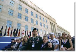 Sitting in front of the rebuilt section of the Pentagon, service personnel and families listen to President George W. Bush at the Pentagon Observance Wednesday, Sept. 11. "One year ago, men and women and children were killed here because they were Americans. And because this place is a symbol to the world of our country's might and resolve," said the President. "Today, we remember each life. We rededicate this proud symbol and we renew our commitment to win the war that began here." White House photo by Eric Draper.