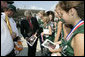 President George W. Bush signs autographs as he meets with members of the 2006 Little League Softball World Series Champions at Bishop International Airport before departing Flint, Mich. White House photo by Kimberlee Hewitt