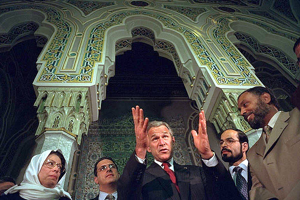 After addressing the media, President George Bush talks with his hosts during his visit to the Islamic Center of Washington, D.C. Sept. 17, 2001. "And it is my honor to be meeting with leaders who feel just the same way I do. They're outraged, they're sad," said the President during his remarks. "They love America just as much as I do.". White House photo by Eric Draper.