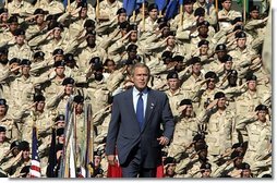 President George W. Bush walks on stage before addressing military personnel and their families at Ft. Stewart, Ga., Friday, Sept. 12, 2003.  White House photo by Paul Morse