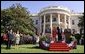 President Bush, President Arroyo, Mrs. Bush and Mr. Arroyo (far left) stand for the playing of the national anthems of the United States and the Philippines at the beginning of the ceremony.  White House photo by Eric Draper