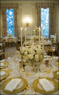 The tables in the State Dining Room are set with the Clinton Millennium China in anticipation of the arrival of 134 guests. Alternating between candelabras and containers from the White House Vermeil Collection, the centerpieces roses adorn 13 tables that are set with the Clinton China in the State Dining Room Monday, May 7, 2007. The President's House crystal stands next to the Vermeil flatware. White House photo by Shealah Craighead