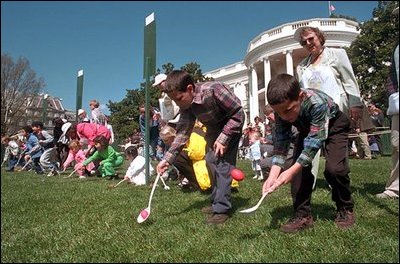 Children race to reach the finish line by rolling hard-boiled eggs across the South Lawn of the White House during the annual White House Easter Egg Roll April 1, 2002. Honoring an Easter tradition that President Rutherford B. Hayes started in 1878, President George W. Bush and Mrs. Bush opened the peoples' home to children, games and many rolling Easter eggs.